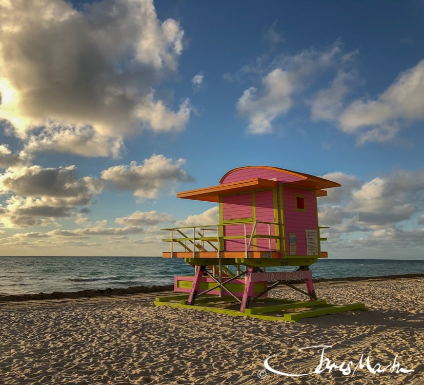 A colourful lifeguard tower beside the sea under a cloudy sky